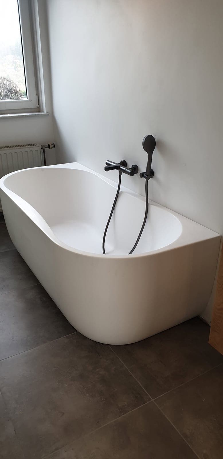 Baignoire blanche et robinetterie murale sombre