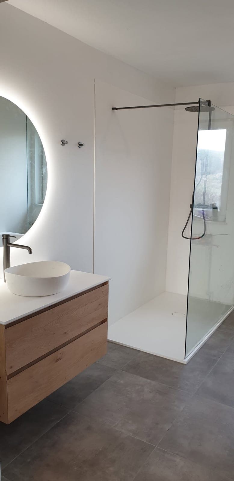 Vue d’ensemble de la salle de bain terminée avec meuble vasque et douche