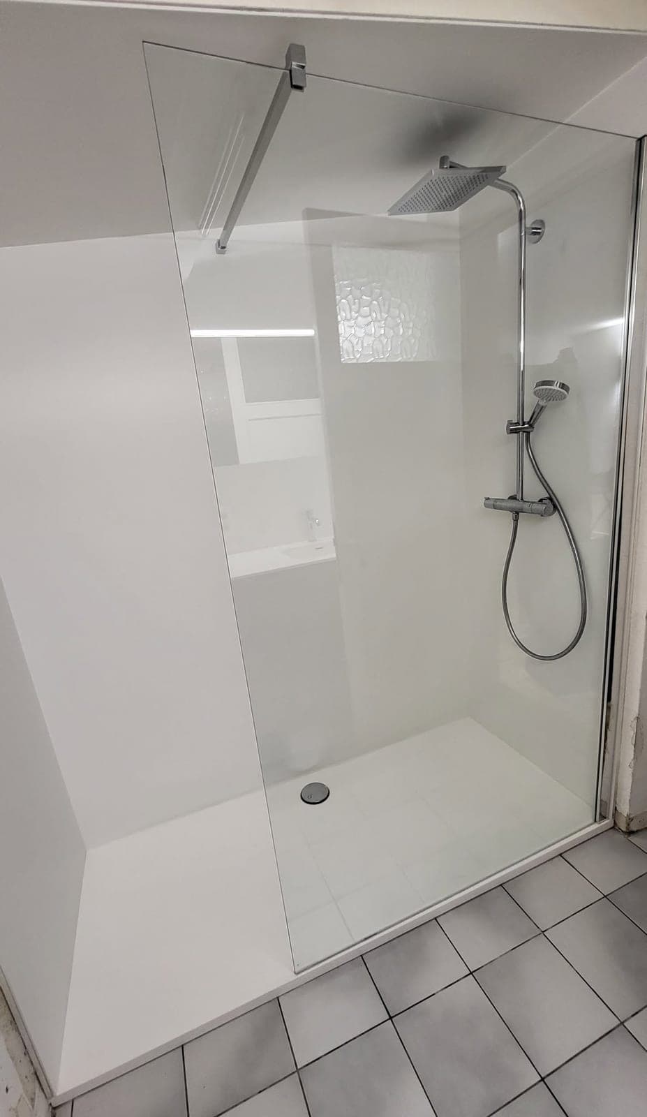 Grande douche blanche avec paroi vitrée dans une petite salle de douche à Ciney