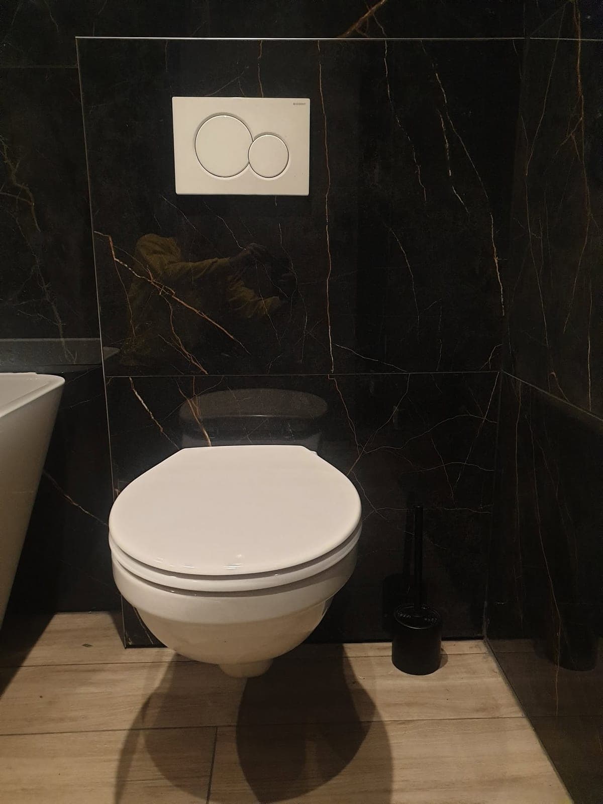 WC suspendu intégré au revêtement mural sombre